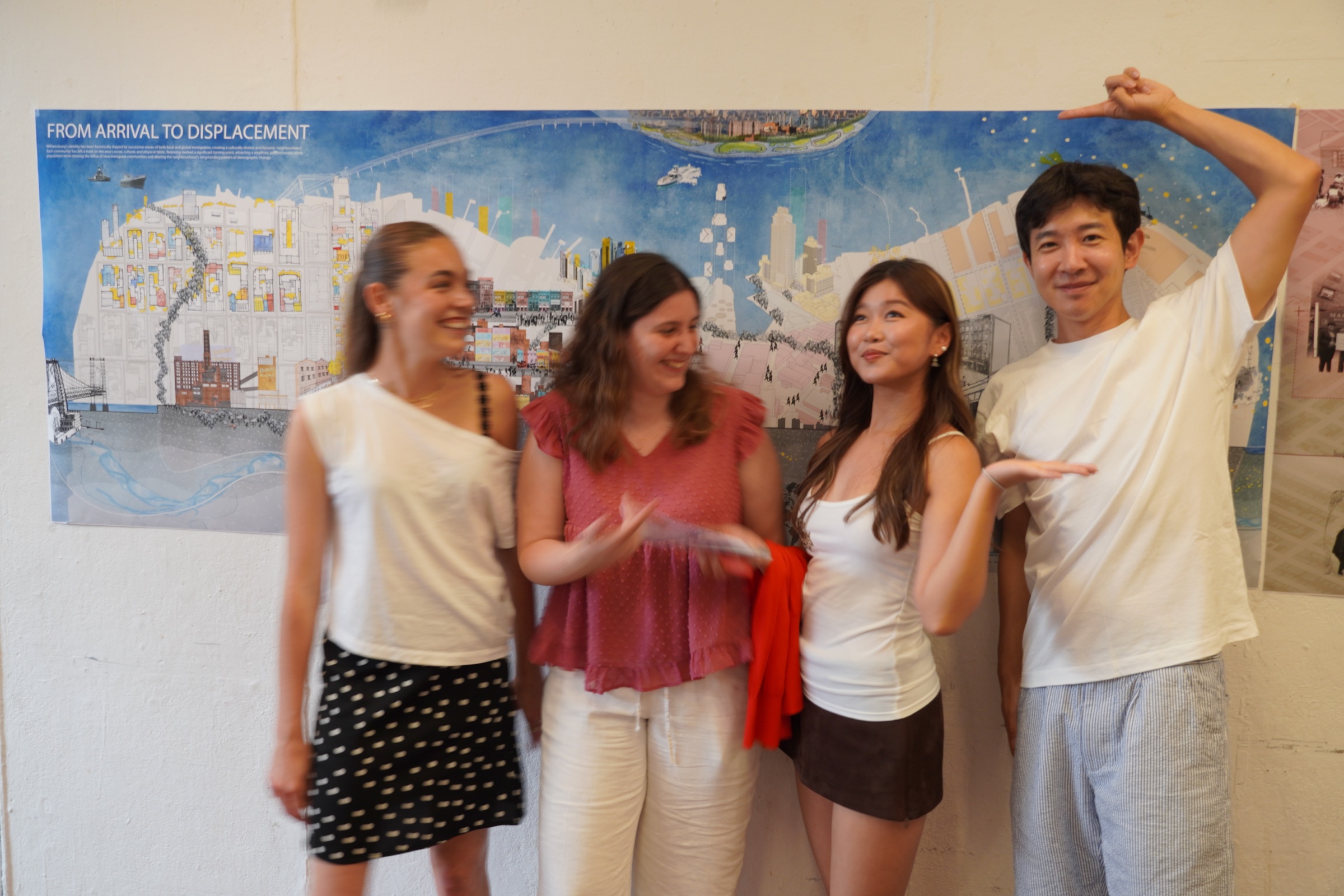 Studio team standing together in front of the From Arrival to Displacement presentation